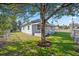 A side view of this charming home with a fenced yard and mature trees at 602 E Orange St, Auburndale, FL 33823