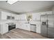 Kitchen with white cabinetry, stainless steel appliances and hardwood floors at 602 E Orange St, Auburndale, FL 33823