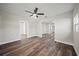 Living room featuring dark ceiling fan, laminate wood flooring and multiple windows at 602 E Orange St, Auburndale, FL 33823