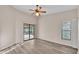 This bedroom features a ceiling fan and sliding glass doors to a porch area, with wood-look flooring at 6224 Crane Dr, Lakeland, FL 33809