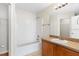 Bright bathroom featuring a vanity with wooden cabinets and a shower-tub combination at 623 Nicholson Dr, Davenport, FL 33837