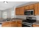 The kitchen shows stainless steel appliances and ample wood cabinetry for storage at 623 Nicholson Dr, Davenport, FL 33837