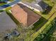 Aerial view of a well-maintained home featuring a roof, a green lawn, and lush landscaping at 6271 Res Cir, Lakeland, FL 33810