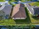 Aerial view of a well-maintained home featuring a roof, a green lawn, and lush landscaping at 6271 Res Cir, Lakeland, FL 33810