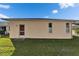 Backyard view of a home featuring a well-maintained lawn, clean exterior, and windows at 6271 Res Cir, Lakeland, FL 33810