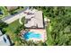 Aerial shot of a community pool with sun loungers and tropical trees, near a well-kept building at 6271 Res Cir, Lakeland, FL 33810