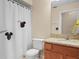 Bathroom featuring a shower with Mickey Mouse themed curtain, a wooden vanity, and a toilet at 6337 Egret Dr, Lakeland, FL 33809