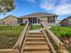 Steps leading to backyard with fence, lush lawn and patio seating area at 6838 Shimmering Dr, Lakeland, FL 33813