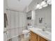 Bright bathroom with gray polka dot shower curtain and wood vanity at 6838 Shimmering Dr, Lakeland, FL 33813