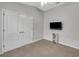 Neutral bedroom featuring wall-mounted TV, ceiling fan and double door closet at 6838 Shimmering Dr, Lakeland, FL 33813