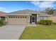 Charming single-story home with a well-maintained lawn, attached garage, and a cozy screened front entrance at 6838 Shimmering Dr, Lakeland, FL 33813