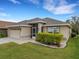 Well-manicured front yard with a charming single-story home, attached garage, and a cozy screened front entrance at 6838 Shimmering Dr, Lakeland, FL 33813