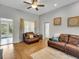 Comfortable living room with hardwood floors, ceiling fan, and stylish decor, featuring a cozy seating area at 6838 Shimmering Dr, Lakeland, FL 33813