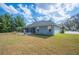 Scenic view of the backyard featuring well-manicured lawn and mature trees surrounding the property's screened in patio at 6846 Ashbury Dr, Lakeland, FL 33809