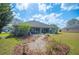 Backyard featuring a decorative stone pathway, lush landscaping, and a screened-in porch at 6846 Ashbury Dr, Lakeland, FL 33809