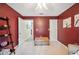 Bedroom with plush carpet, red walls, ceiling fan, and a doorway to an adjacent room at 6846 Ashbury Dr, Lakeland, FL 33809