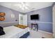 This bedroom features blue walls, a ceiling fan, and a comfortable bed with colorful accents at 6846 Ashbury Dr, Lakeland, FL 33809