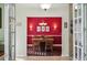 Bright dining room featuring a red accent wall, hardwood floors, and a modern chandelier at 6846 Ashbury Dr, Lakeland, FL 33809