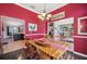 Inviting dining room with bright red walls, wood floors and table set for a meal at 6846 Ashbury Dr, Lakeland, FL 33809