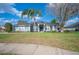 Inviting home exterior featuring a well-manicured lawn, a palm tree and lush landscaping, enhancing curb appeal at 6846 Ashbury Dr, Lakeland, FL 33809