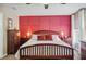 This main bedroom showcases a red accent wall, wood furnishings, and a large bed at 6846 Ashbury Dr, Lakeland, FL 33809