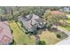 Aerial view of a luxury home with a screened in pool and sprawling backyard surrounded by mature trees at 6942 Indian Creek Park Dr, Lakeland, FL 33813