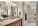 Bathroom vanity area with marble countertop, tile backsplash, framed mirror and decorative lighting at 6942 Indian Creek Park Dr, Lakeland, FL 33813