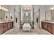 A luxurious bathroom with double vanity sinks, a chandelier, and large soaking tub at 6942 Indian Creek Park Dr, Lakeland, FL 33813