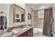 Elegant bathroom featuring a shower-tub combo with neutral tile and a marble vanity with a decorative mirror at 6942 Indian Creek Park Dr, Lakeland, FL 33813