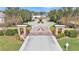 Gated entrance to the community featuring brick pillars, mature trees, and manicured landscaping at 6942 Indian Creek Park Dr, Lakeland, FL 33813