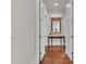 Hallway with decorative mirror, hardwood floors, and white trim, creating a clean and inviting transition space at 6942 Indian Creek Park Dr, Lakeland, FL 33813