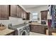 Well-equipped laundry room featuring ample cabinetry, granite counters, a sink, and modern washer and dryer at 6942 Indian Creek Park Dr, Lakeland, FL 33813