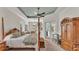 Tranquil main bedroom with a four-poster bed, tray ceiling, and French doors leading to a private outdoor area at 6942 Indian Creek Park Dr, Lakeland, FL 33813