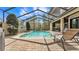 Screened-in pool with a waterfall feature, brick patio, and easy access to an outdoor living area at 6942 Indian Creek Park Dr, Lakeland, FL 33813