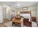 Comfortable main bedroom featuring a decorative bench, wood-look floors, and bedside tables with lamps at 720 Lake Jessie Dr, Winter Haven, FL 33881