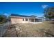 Home's backyard featuring solar panels, a screened patio, chain-link fence, and ample space at 736 Hunt Dr, Lake Wales, FL 33853