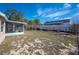 Spacious backyard with a screened-in porch, bordered by a fence and greenery for privacy at 736 Hunt Dr, Lake Wales, FL 33853