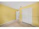 A yellow bedroom with standard closet and neutral carpeting at 736 Hunt Dr, Lake Wales, FL 33853