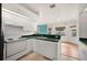 Bright kitchen featuring white appliances and cabinets and an eat-in counter that overlooks the dining area at 736 Hunt Dr, Lake Wales, FL 33853