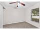 This bedroom features neutral carpeting, a ceiling fan, and a window providing ample natural light at 7444 Hunters Greene Cir, Lakeland, FL 33810