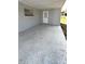 Spacious carport with concrete flooring and an exit door at 745 4Th St, Polk City, FL 33868