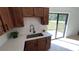 Kitchen sink features shaker cabinets, quartz countertops, a white backsplash, and a sliding glass door at 745 4Th St, Polk City, FL 33868