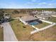 Aerial view of home with screened pool, fenced yard, and peaceful surroundings at 824 Ulmer Rd, Frostproof, FL 33843