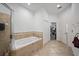 Large soaking tub in bathroom featuring ceramic tile floors and linen closet at 824 Ulmer Rd, Frostproof, FL 33843