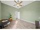 Spacious bedroom features wood-look floors, ceiling fan, and neutral green paint at 824 Ulmer Rd, Frostproof, FL 33843