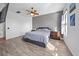 Bedroom with wood floors, neutral grey decor, ceiling fan, and ensuite bathroom at 824 Ulmer Rd, Frostproof, FL 33843