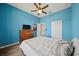 Bedroom features a ceiling fan, dresser and bright blue accent wall at 824 Ulmer Rd, Frostproof, FL 33843