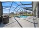 Backyard view of the screened pool, spa, and spacious patio, perfect for entertaining at 824 Ulmer Rd, Frostproof, FL 33843