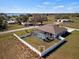 Rear exterior view of a home with a screened-in lanai pool and white fenced in yard at 824 Ulmer Rd, Frostproof, FL 33843