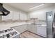 A bright kitchen equipped with white cabinets, appliances, and modern backsplash at 827 Sherwood Dr, Lake Wales, FL 33898